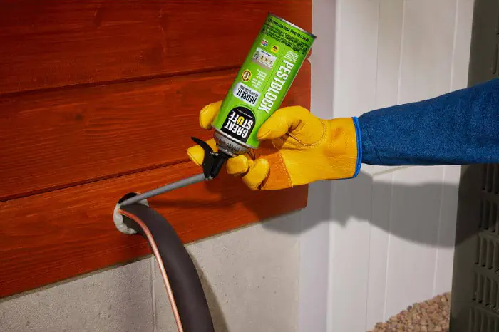 Can of Great Stuff foam insulation sealing an AC line